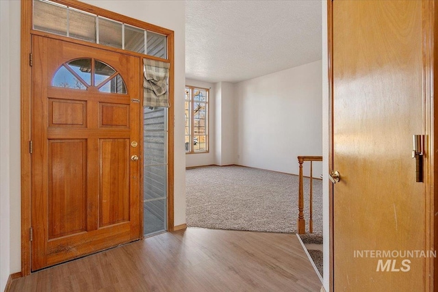 foyer with a textured ceiling and wood finished floors