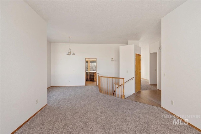 carpeted empty room featuring a textured ceiling