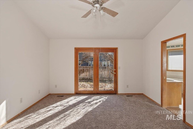 unfurnished room with lofted ceiling, ceiling fan, carpet, and baseboards