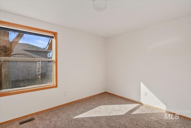 unfurnished room featuring baseboards, visible vents, and carpet flooring