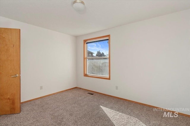 carpeted empty room with visible vents and baseboards