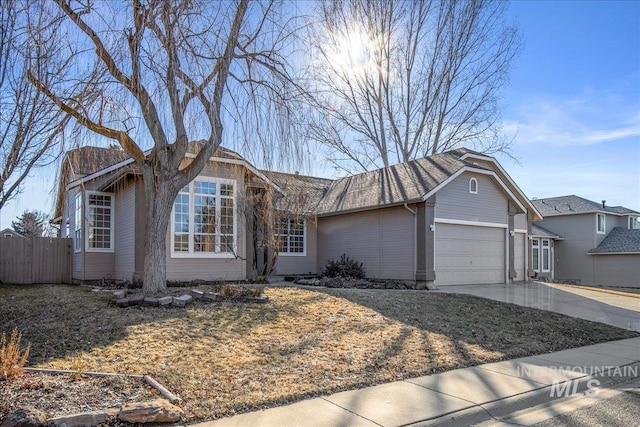 ranch-style house with a garage, driveway, and fence