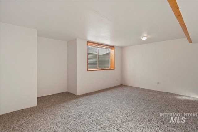 additional living space featuring carpet floors and beam ceiling