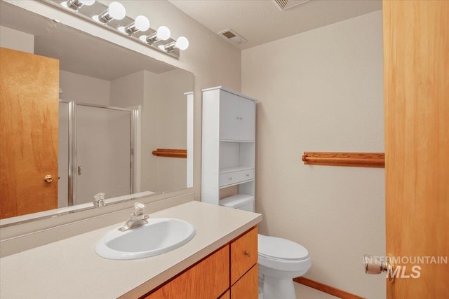 full bathroom featuring toilet, a stall shower, vanity, and visible vents