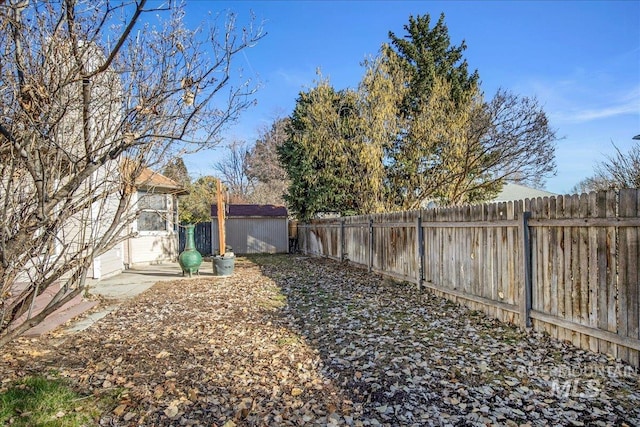 view of yard with a storage shed, an outdoor structure, and a fenced backyard