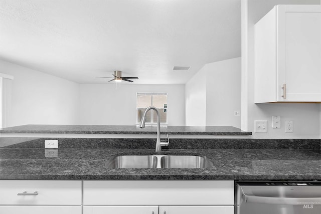 1590 Saddler St, Twin Falls, ID 83301 - kitchen with stainless steel dishwasher, a sink, white cabinetry, ceiling fan, and dark stone countertops