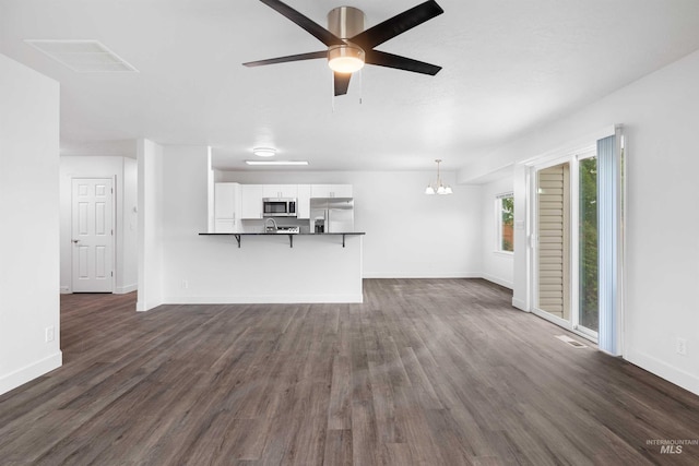 1590 Saddler St, Twin Falls, ID 83301 - unfurnished living room with dark wood-style floors, baseboards, a chandelier, and a ceiling fan