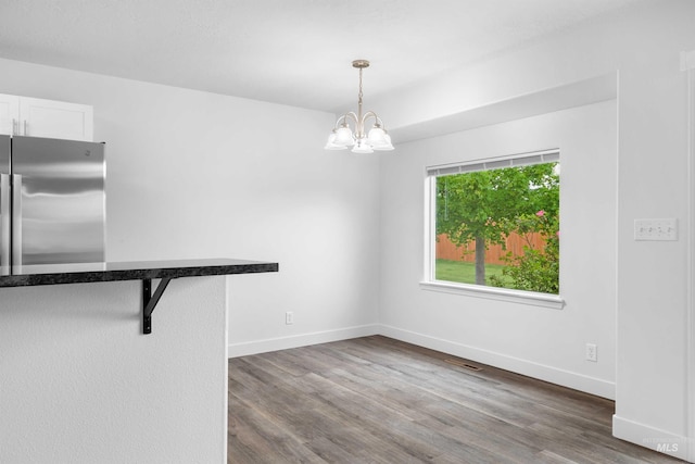 1590 Saddler St, Twin Falls, ID 83301 - unfurnished dining area with dark wood finished floors, a chandelier, and baseboards