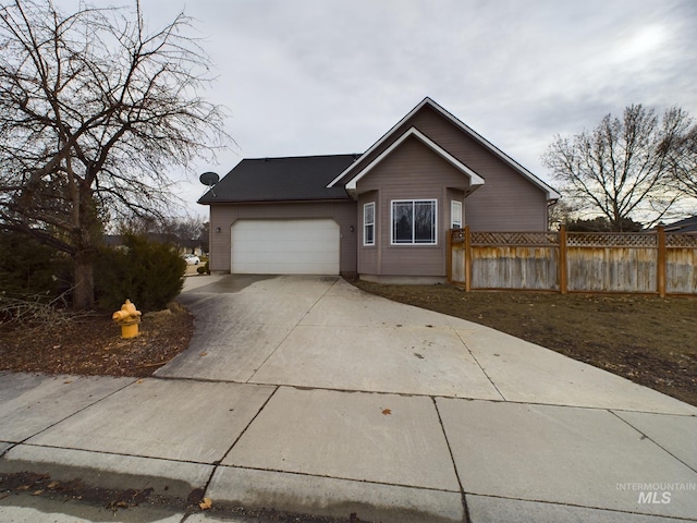 ranch-style home with driveway, an attached garage, and fence