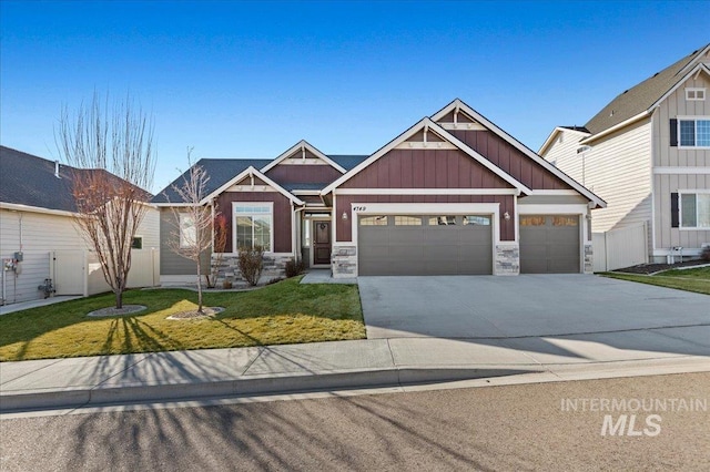 craftsman-style home with a garage, concrete driveway, stone siding, board and batten siding, and a front yard