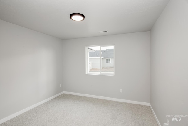 empty room featuring baseboards, visible vents, and carpet flooring