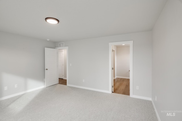 unfurnished bedroom with carpet flooring, visible vents, and baseboards