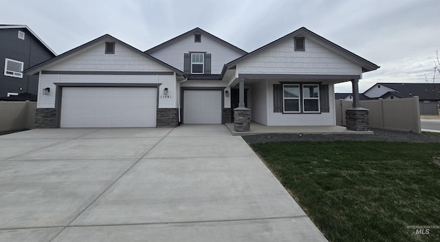 11581 W Trooper St, Nampa, ID 83651 - craftsman house with fence, a garage, concrete driveway, a porch, and a front lawn