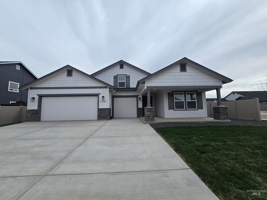 11581 W Trooper St, Nampa, ID 83651 - view of front of house featuring concrete driveway, a garage, fence, and a front lawn
