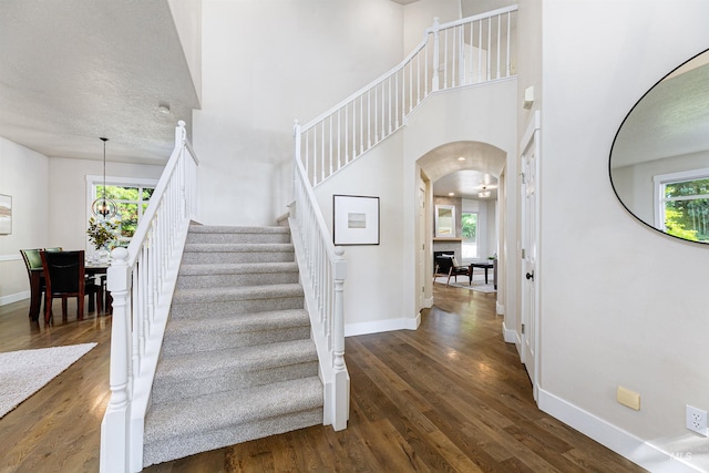 2383 E Lenox Ct, Eagle, ID 83616 - stairs with arched walkways, wood finished floors, baseboards, and a towering ceiling