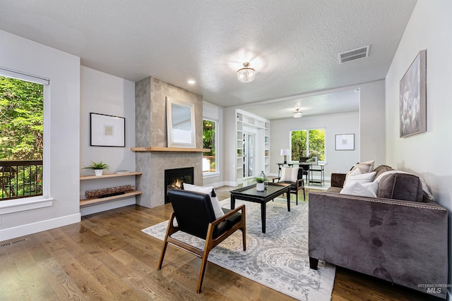 2383 E Lenox Ct, Eagle, ID 83616 - living room featuring a fireplace, wood finished floors, baseboards, and a textured ceiling