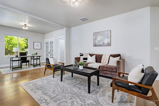 2383 E Lenox Ct, Eagle, ID 83616 - living area with wood finished floors, a desk, a textured ceiling, french doors, and baseboards