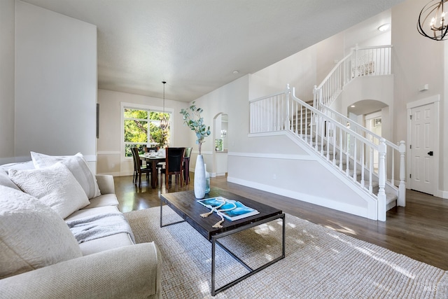 2383 E Lenox Ct, Eagle, ID 83616 - living room with arched walkways, wood finished floors, a chandelier, stairs, and baseboards