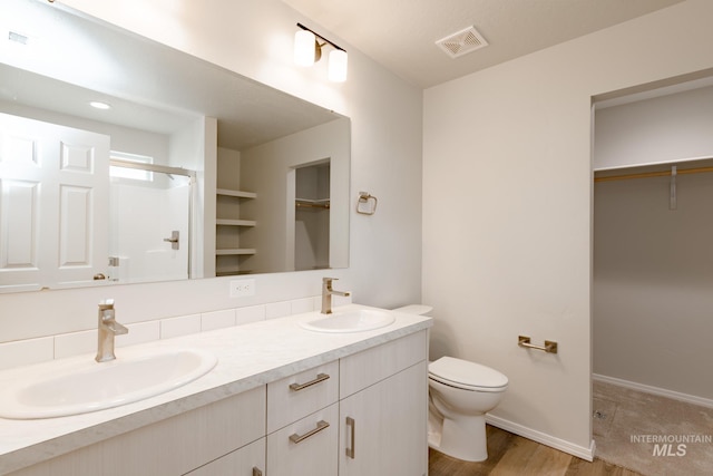5315 E Burnte Peak St, Nampa, ID 83687 - bathroom with double vanity, a spacious closet, toilet, and wood finished floors