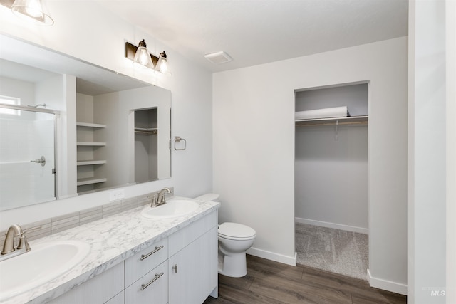 5315 E Burnte Peak St, Nampa, ID 83687 - bathroom featuring a walk in closet, double vanity, wood finished floors, a stall shower, and toilet