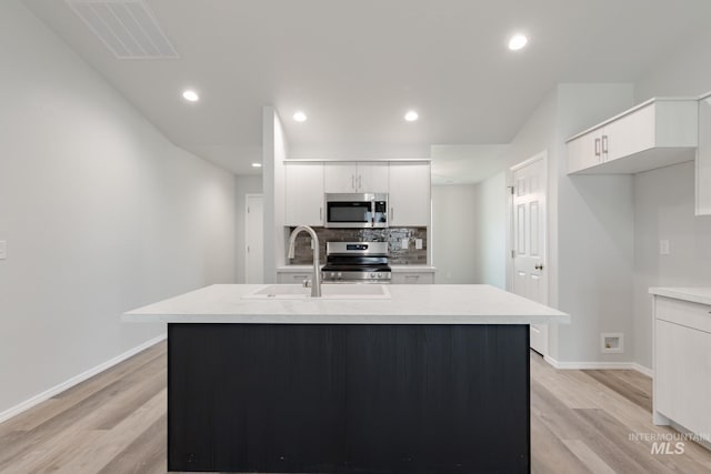 5315 E Burnte Peak St, Nampa, ID 83687 - kitchen featuring appliances with stainless steel finishes, a sink, light countertops, light wood-style flooring, and white cabinets