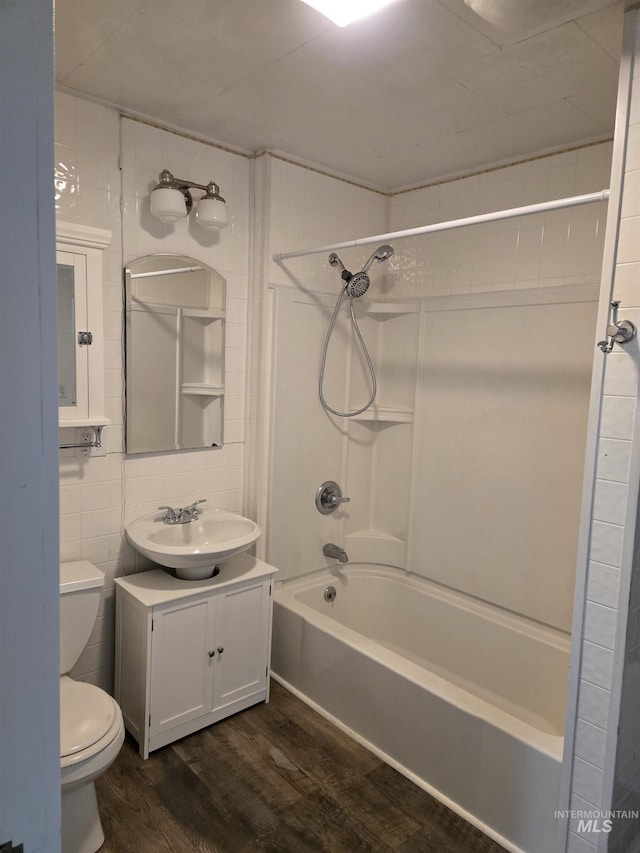 628 Main St, Orofino, ID 83544 - full bath with wood finished floors, toilet, vanity, shower / tub combination, and tile walls