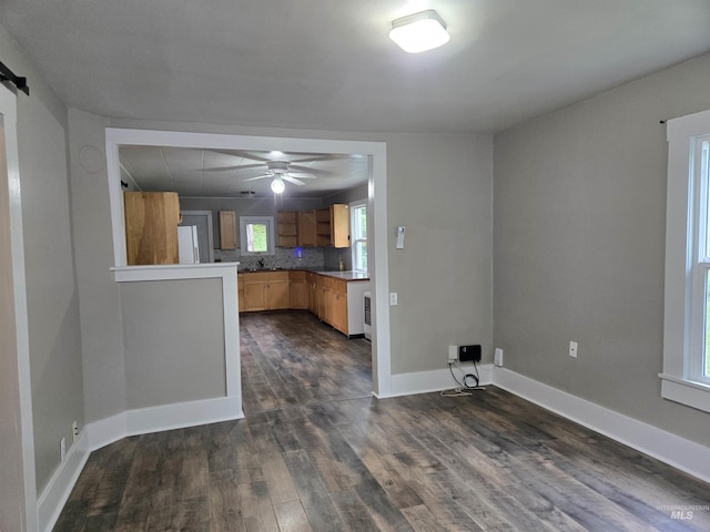 628 Main St, Orofino, ID 83544 - kitchen with dark wood-type flooring, a ceiling fan, baseboards, light brown cabinetry, and decorative backsplash