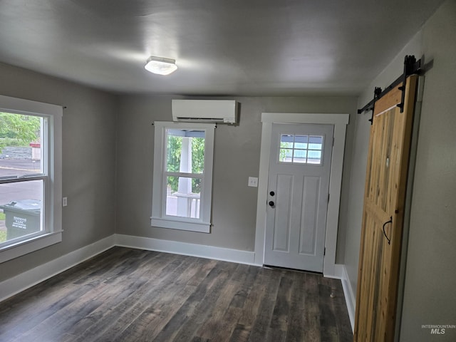 628 Main St, Orofino, ID 83544 - foyer featuring a wall unit AC, baseboards, a barn door, and dark wood-style flooring