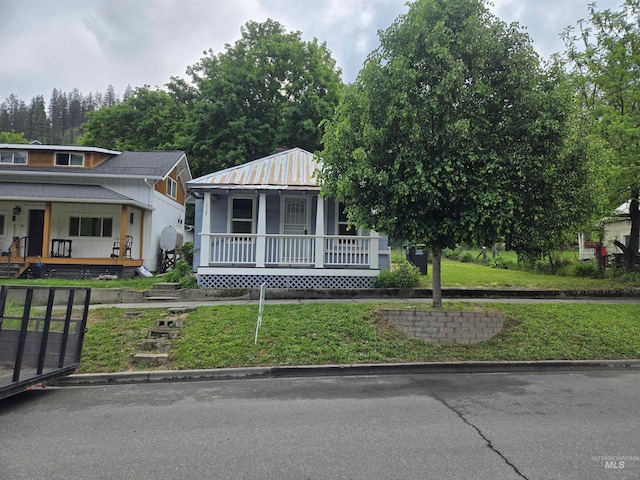 628 Main St, Orofino, ID 83544 - view of front facade featuring a porch, metal roof, and a front yard