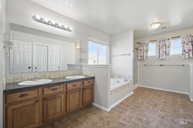 841 Shire St, Middleton, ID 83644 - bathroom featuring a textured ceiling, a bath, double vanity, a shower stall, and baseboards