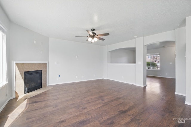 841 Shire St, Middleton, ID 83644 - unfurnished living room featuring a ceiling fan, a fireplace, wood finished floors, baseboards, and arched walkways