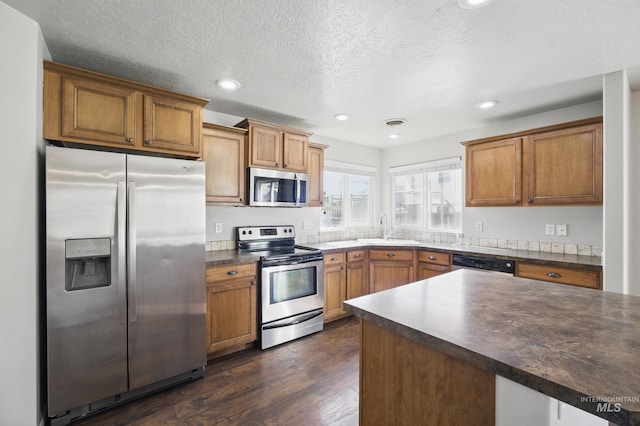841 Shire St, Middleton, ID 83644 - kitchen with appliances with stainless steel finishes, dark countertops, brown cabinets, a sink, and recessed lighting