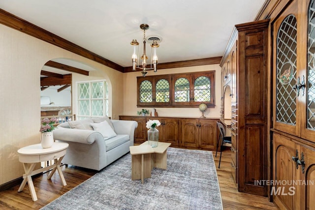 928 N Argyll Dr, Boise, ID 83702 - living room with plenty of natural light, light wood-style flooring, arched walkways, a chandelier, and crown molding