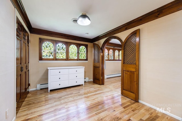 928 N Argyll Dr, Boise, ID 83702 - empty room with a baseboard radiator, light wood finished floors, baseboards, arched walkways, and ornamental molding