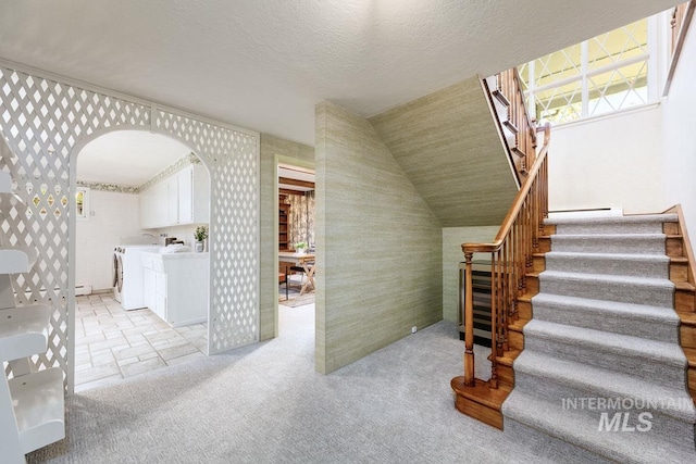 928 N Argyll Dr, Boise, ID 83702 - staircase featuring washer and clothes dryer, arched walkways, wallpapered walls, carpet flooring, and a baseboard heating unit