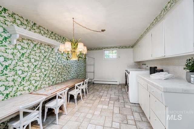 928 N Argyll Dr, Boise, ID 83702 - laundry room with baseboard heating, a chandelier, washing machine and dryer, and brick patterned flooring