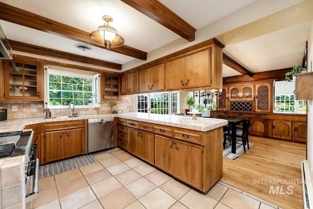 928 N Argyll Dr, Boise, ID 83702 - kitchen featuring stainless steel appliances, a peninsula, tile countertops, beam ceiling, and tasteful backsplash