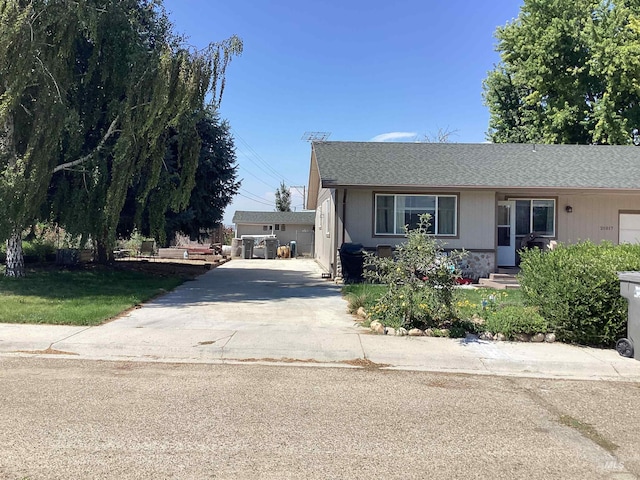 view of front of home with a front yard, a garage, and an outbuilding