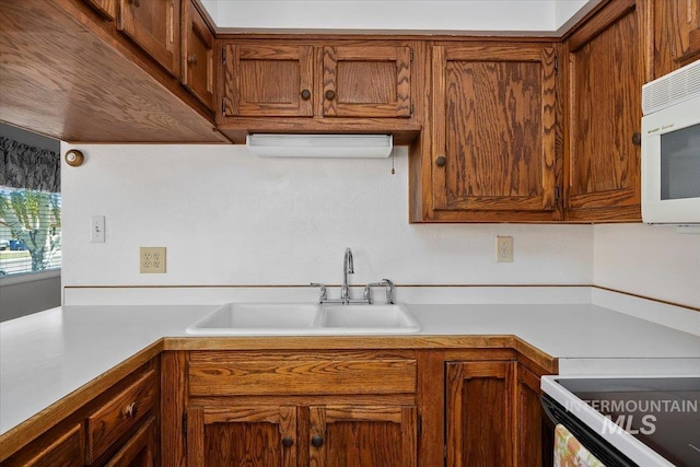 371 Dubois, Twin Falls, ID 83301 - kitchen featuring a sink, white microwave, brown cabinets, and light countertops