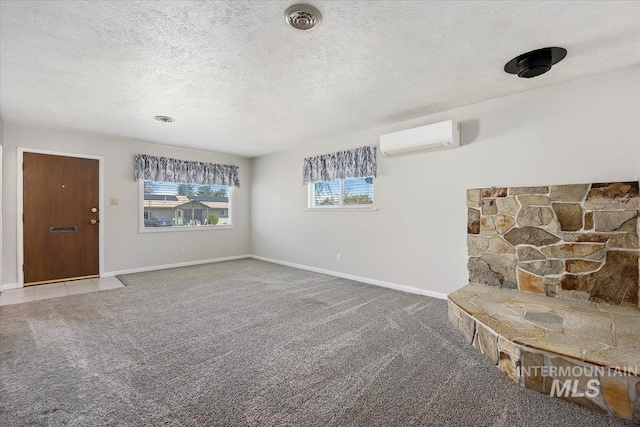 371 Dubois, Twin Falls, ID 83301 - unfurnished living room with an AC wall unit, baseboards, carpet, and a textured ceiling