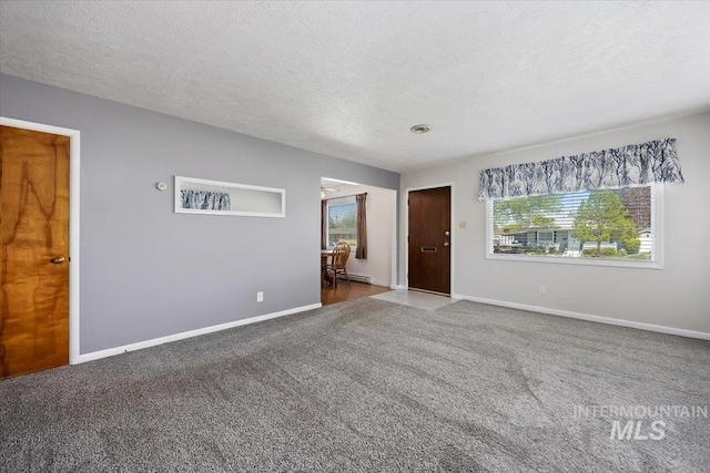 371 Dubois, Twin Falls, ID 83301 - spare room with baseboards, carpet flooring, a textured ceiling, and a baseboard radiator