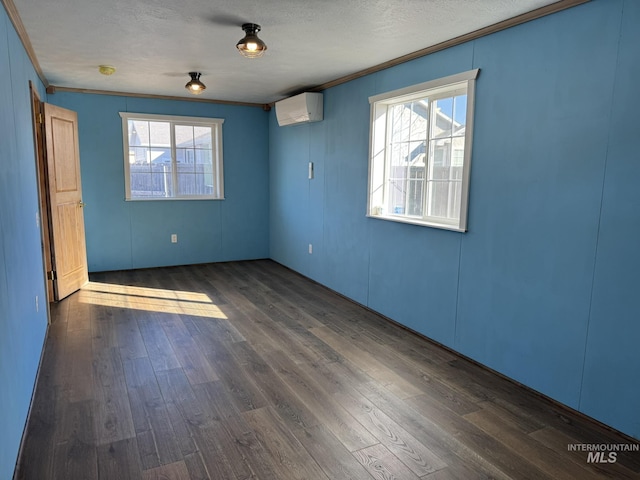 unfurnished room featuring a textured ceiling, an AC wall unit, ornamental molding, and dark wood finished floors