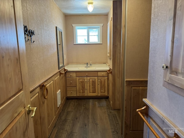 bathroom with a textured ceiling, wood finished floors, and vanity