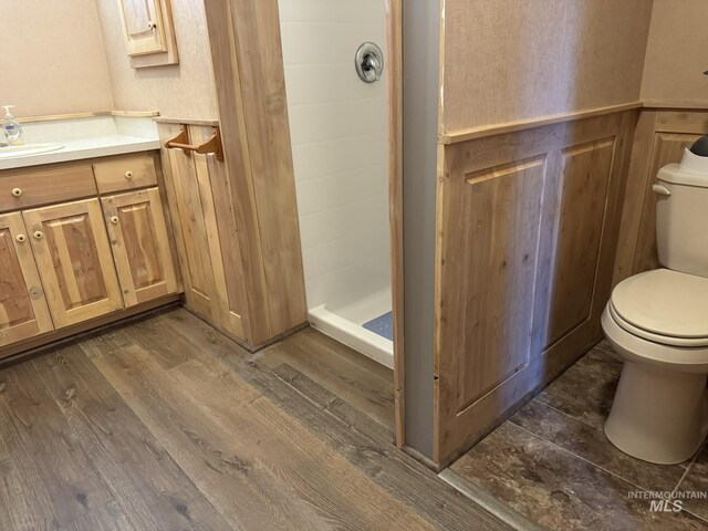 full bathroom with toilet, a stall shower, wood finished floors, and vanity