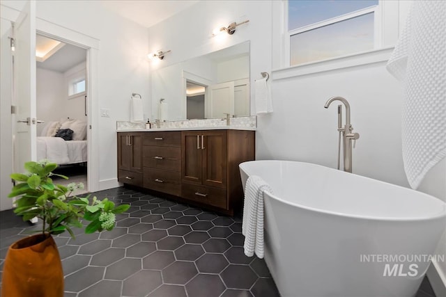 bathroom with a bath, vanity, and tile patterned floors