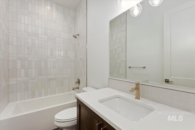 full bathroom with vanity, tiled shower / bath combo, and toilet