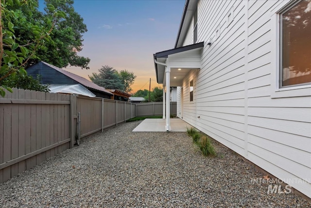 yard at dusk featuring a patio area