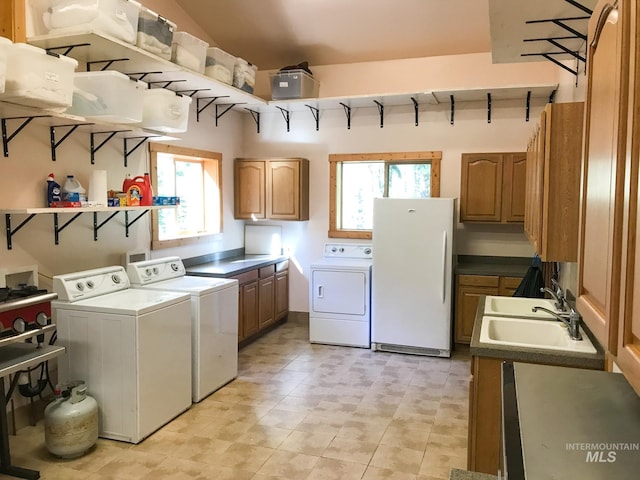 laundry area featuring sink, washer and dryer, and a wealth of natural light