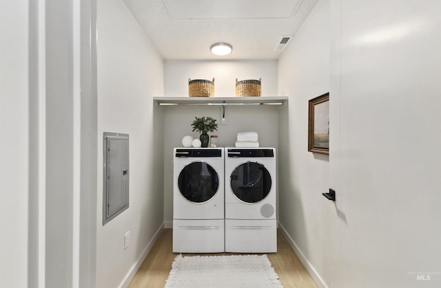 4340 E Haystack St Unit 205, Boise, ID 83716 - laundry room with washing machine and clothes dryer, light wood-style flooring, electric panel, and attic access