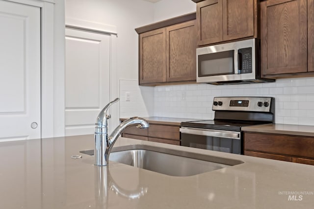 kitchen featuring sink, appliances with stainless steel finishes, and tasteful backsplash